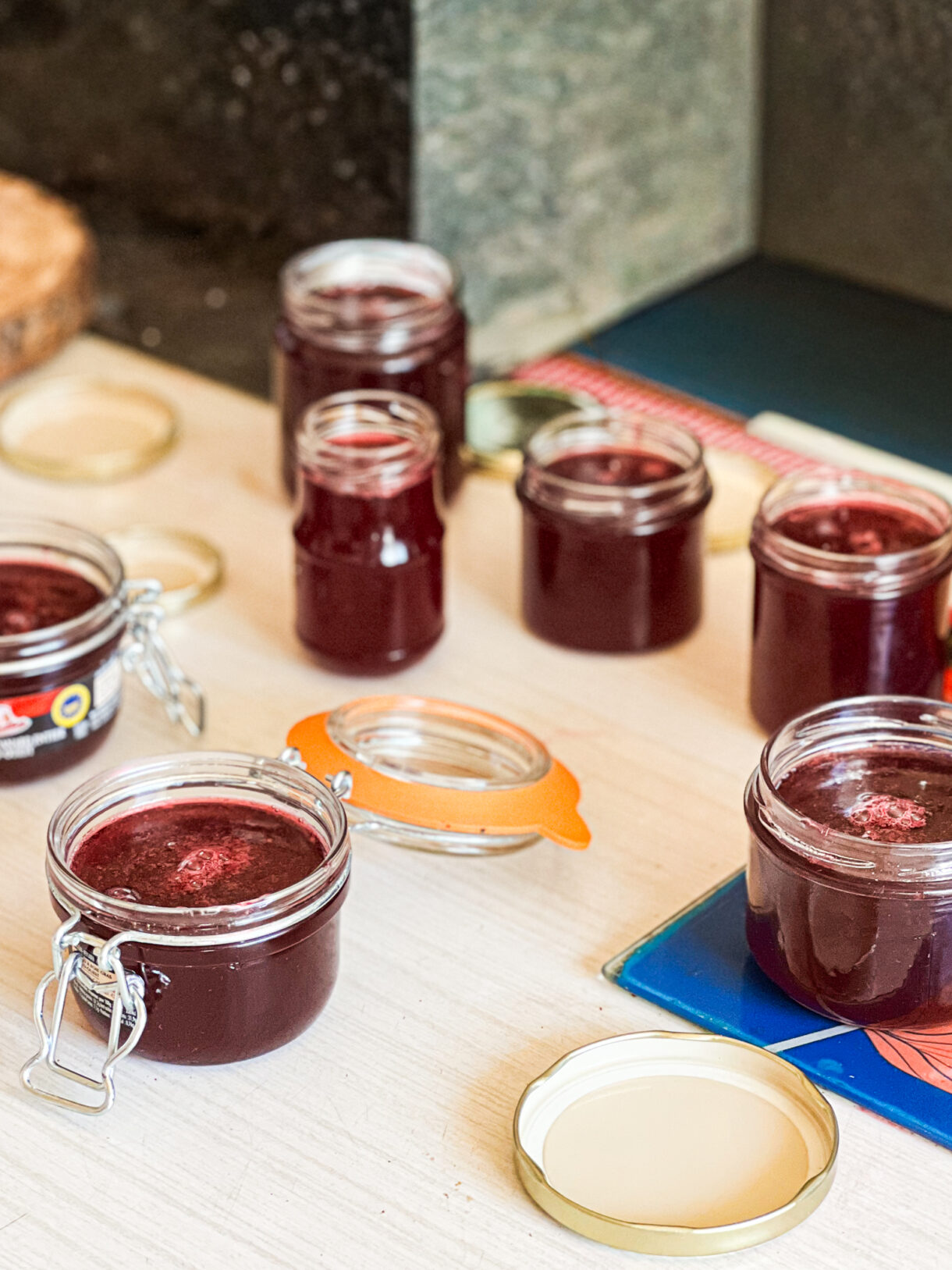 Confiture de raisin Muscat maison dans un pot en verre, avec des raisins frais en arrière-plan.