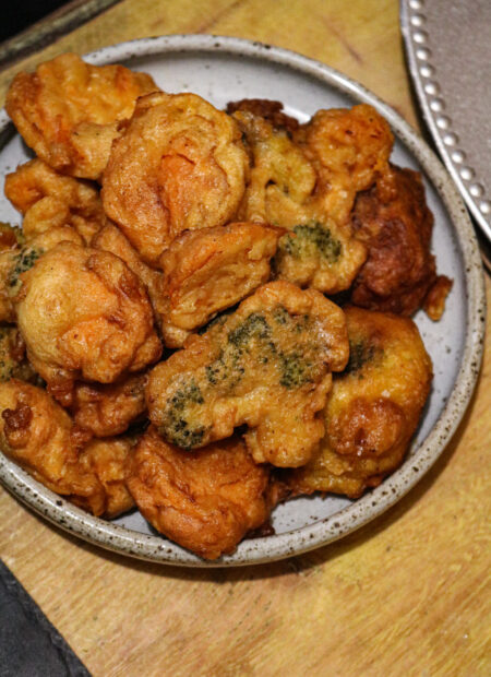Beignets dorés de chou-fleur, brocolis et patate douce dans une assiette en céramique