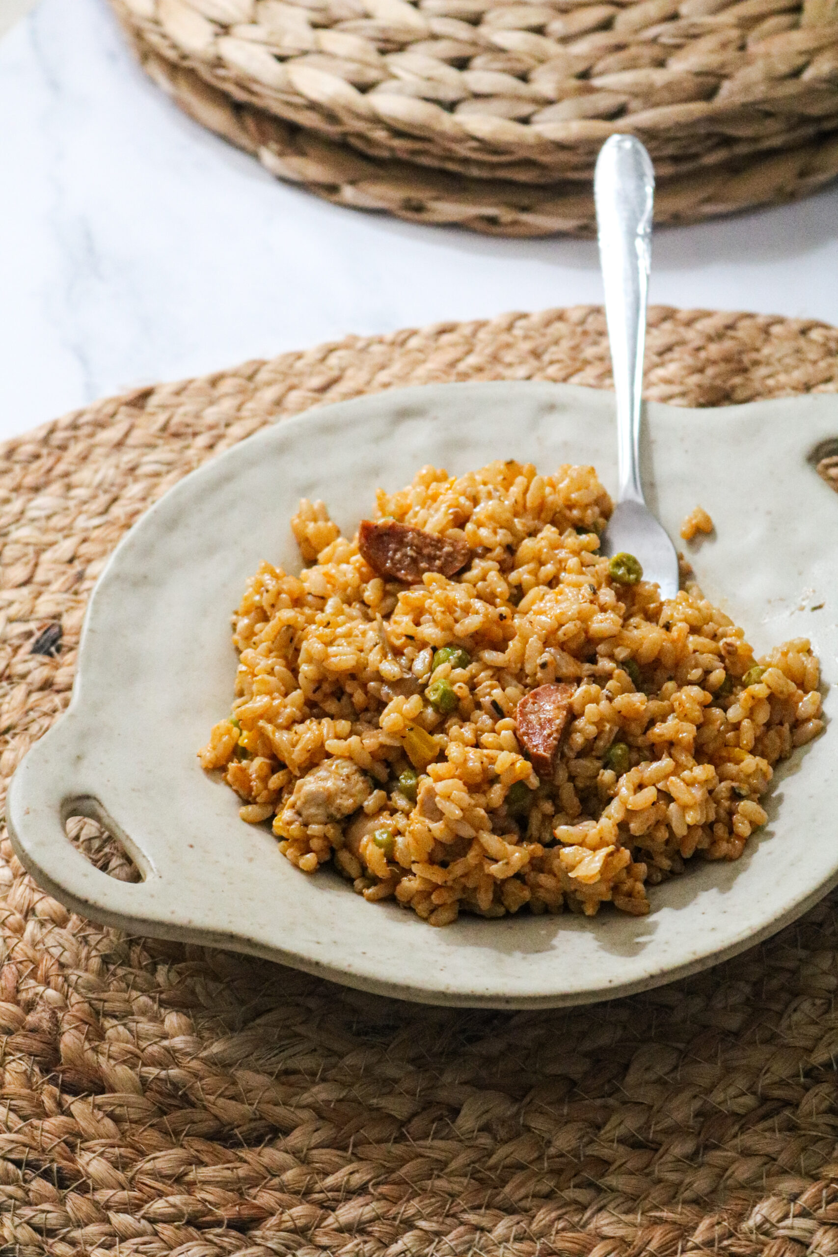 Assiette sur une table avec un risotto au poulet, chorizo et poivron
