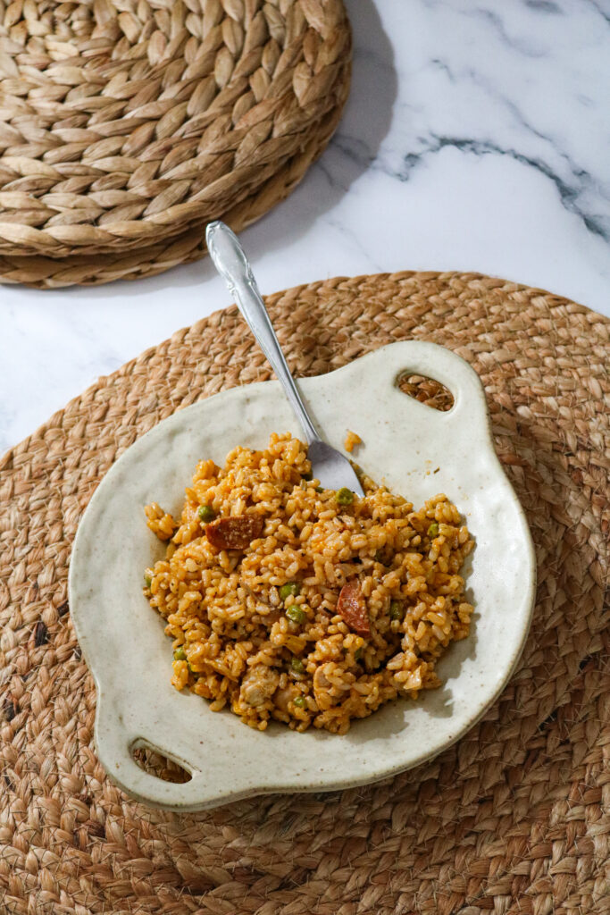 Assiette sur une table avec un risotto au poulet, chorizo et poivron