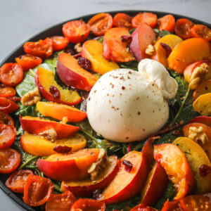 plat avec pêches rôties burrata, pousses épinards et tomates rôties