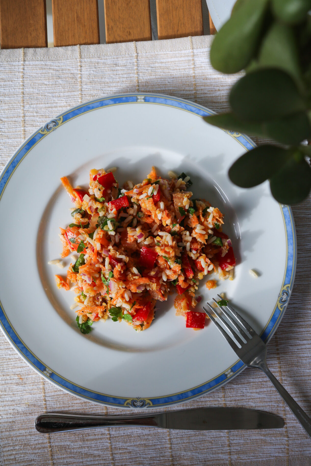 Zoom sur assiette avec ingrédients pour salade de lentilles corail : riz, légumes, citron et huile d’olive