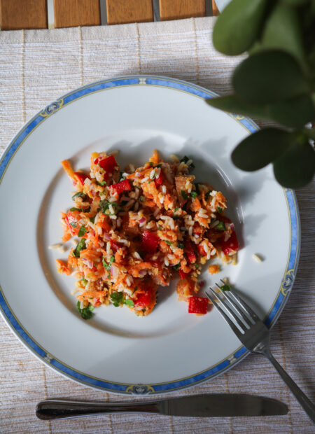 Zoom sur assiette avec ingrédients pour salade de lentilles corail : riz, légumes, citron et huile d’olive