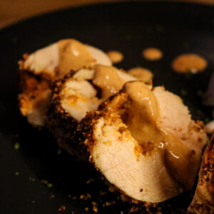 Zoom sur ballotine de poulet farcie avec sauce au curry thaï Penang curry dans une assiette