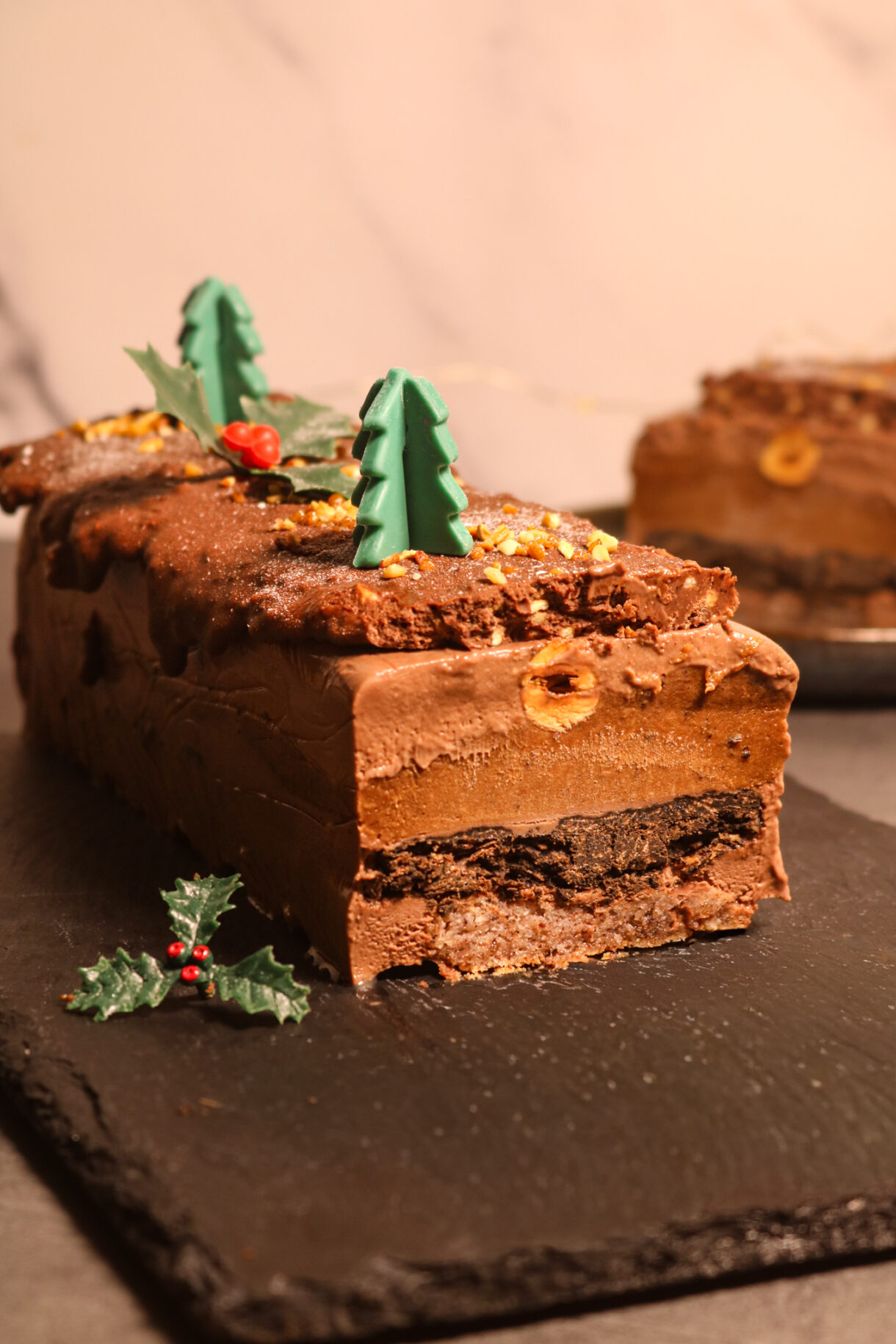 Bûche de Noël noisetté et chocolaté : présentation finale avec un enrobage de chocolat et praliné