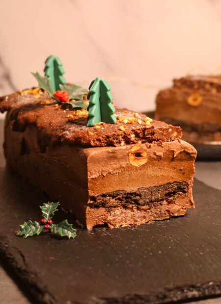 Bûche de Noël noisetté et chocolaté : présentation finale avec un enrobage de chocolat et praliné