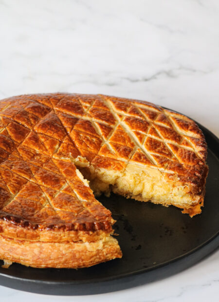 Frangipane maison ouverte sur une assiette avec bases apparente ; crème d’amandes et crème pâtissière