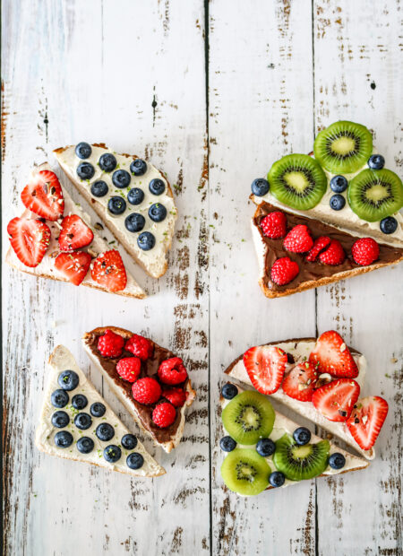 4 toasts sucrées garnies avec des fruits, sur une base de fromage frais