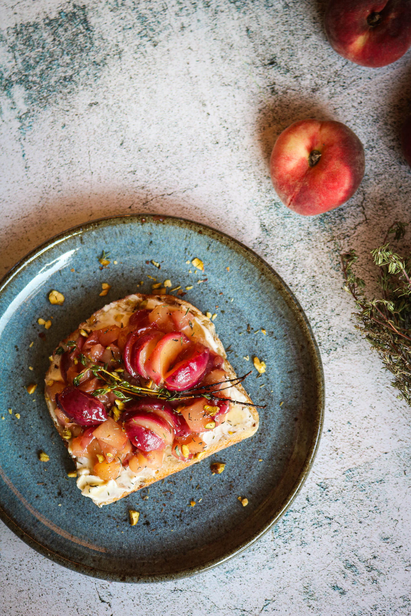 Tartine peche et fromage frais au miel sur une assiette en ceramique bleue