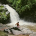 Adeline Bernard assise sur un rocher face à une cascade à Chiang Mai
