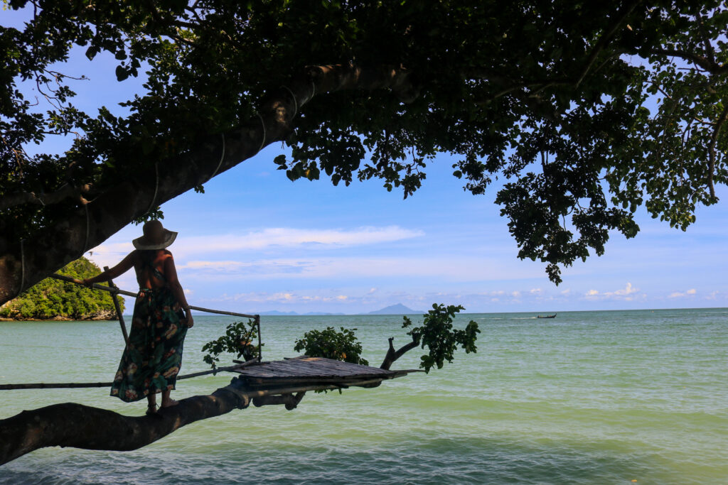 L'auteur qui marche sur un tronc de bois suspendu au dessus de la mer